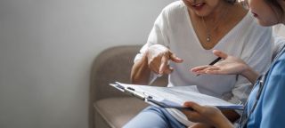 Clinician reviewing paperwork with a patient while discussing Spravato eligibility and next treatment steps