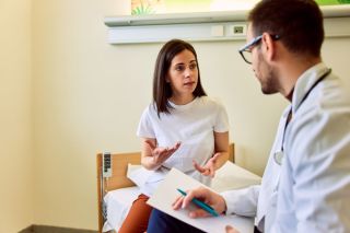 Clinician discussing next-step treatment options with a patient after reviewing Spravato progress